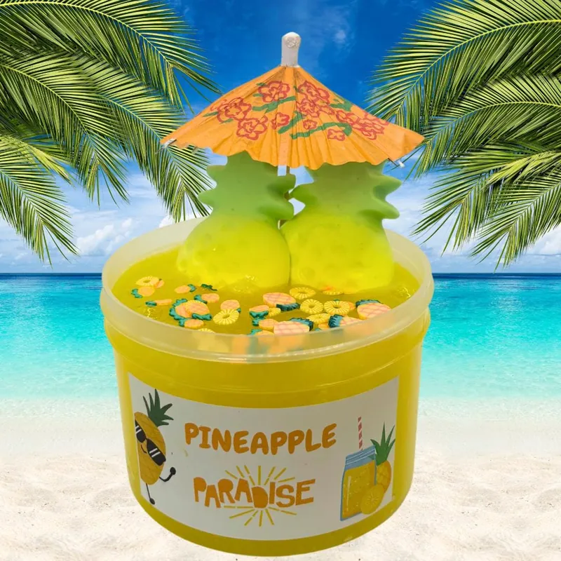 Pineapple Paradise jar of yellow slime with pineapple toppers and a paper umbrella on a beach