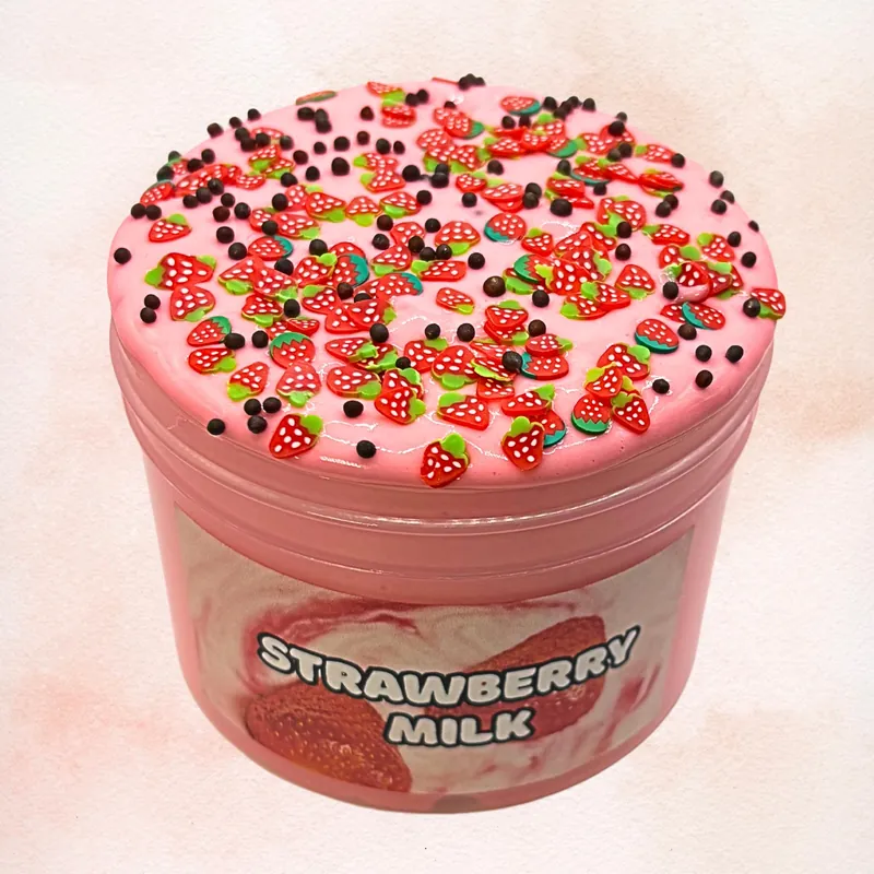 Strawberry Milk slime in its jar, pink and glossy, topped with strawberry charms and dark sprinkles