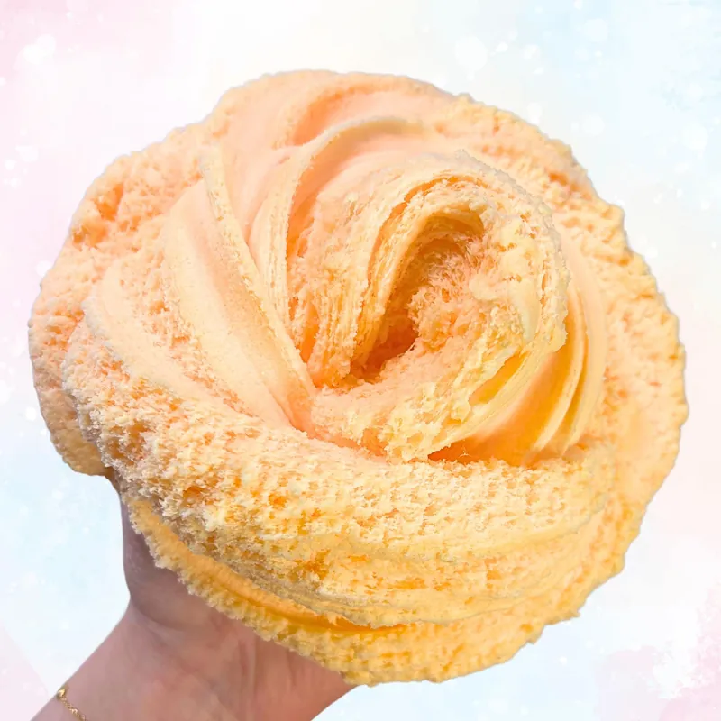 Unicorn Whip slime piped into a rose shape in a hand